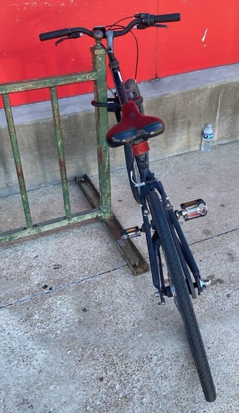 A bike parking "rack" that looks like a small metal fence, way too close to the wall behind it.